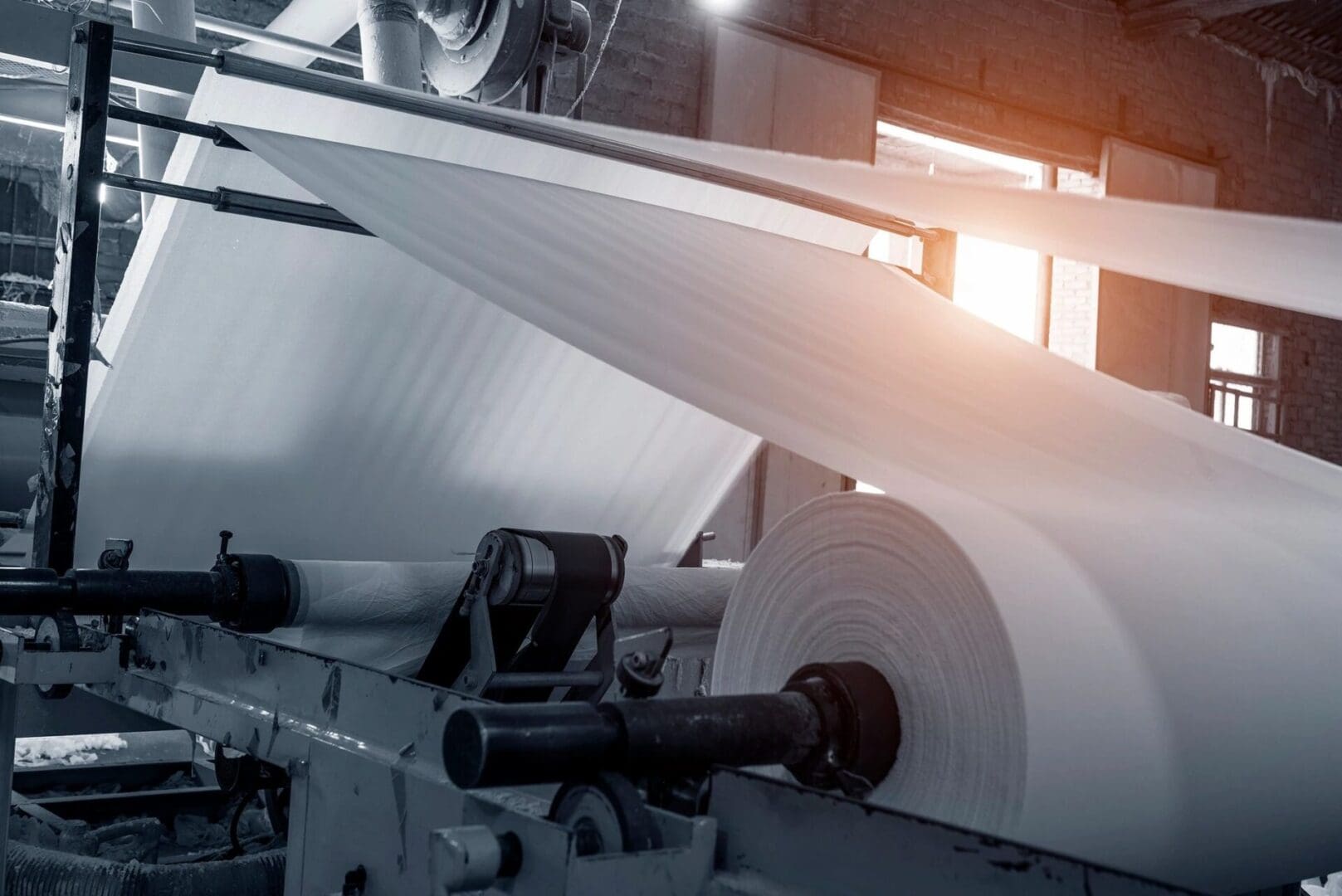 fm=f 22796 A machine that is rolling paper in the middle of a factory.